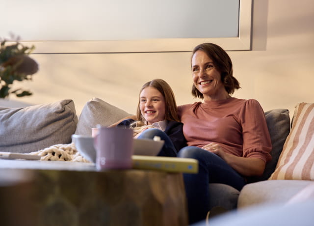 Mother and daughter sitting on the sofa together