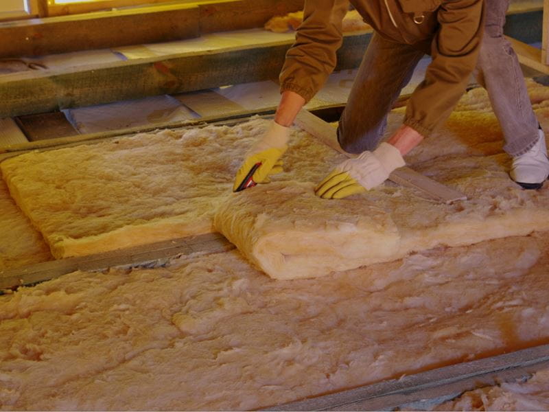 worker cutting insulation fibre on the roof