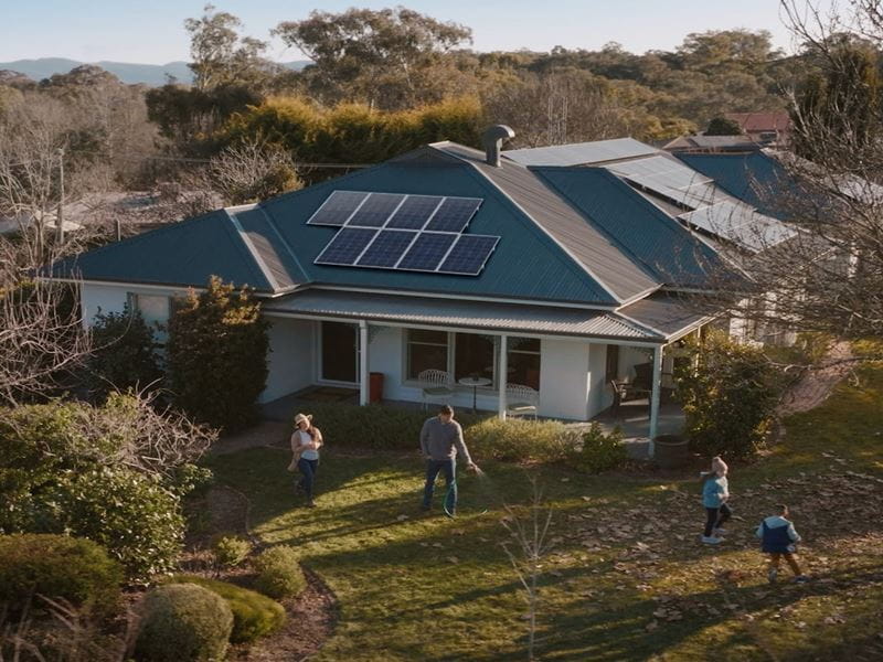 Family spending time in front of a house with solar panels