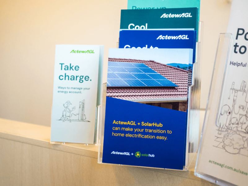 Pamphlets from ActewAGL displayed on a bookshelf.