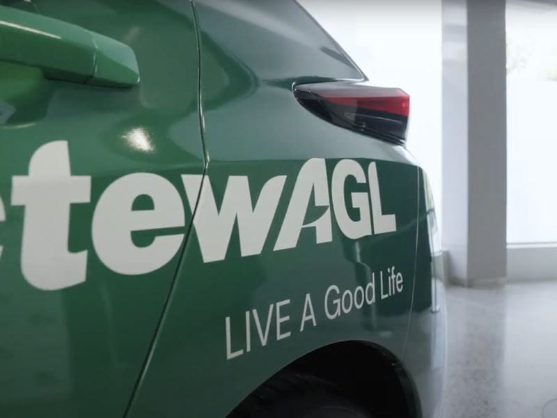 A green electric vehicle with an ActewAGL sticker on the side of it 