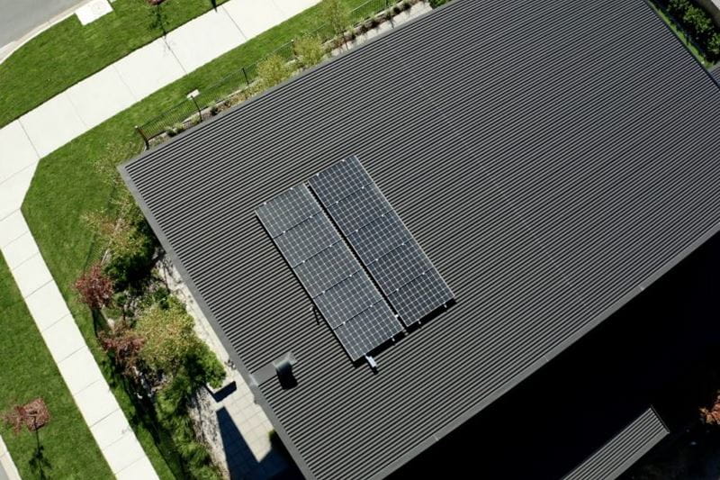 A grey house with solar panels on the roof